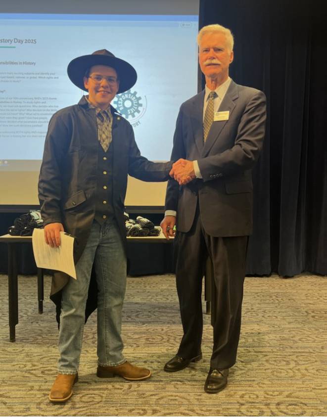 Professor Sean O'Neill shaking hands with a student